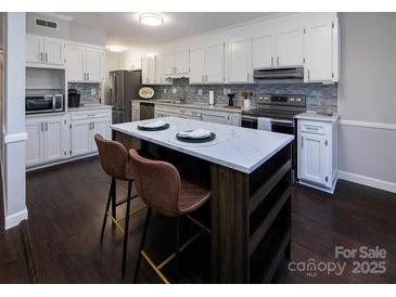 Modern kitchen with white cabinets, stainless steel appliances, and a large island at 6742 Constitution Ln, Charlotte, NC 28210