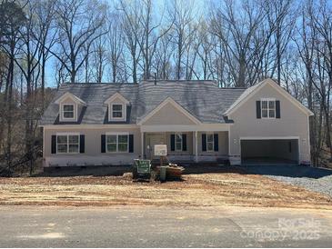 Charming one-story home featuring a side entry garage, dormer windows and a welcoming covered porch at Lot 72.73 Sally Clark Dr, Denver, NC 28037