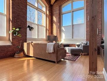 Spacious living room with exposed brick and large windows at 201 S Hoskins Rd # 136, Charlotte, NC 28208