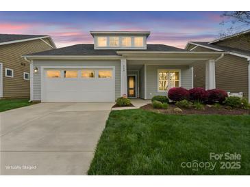 Charming one-story home with well-manicured lawn, covered porch and a two-car garage at 253 Stone Mountain Way, Denver, NC 28037