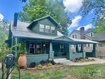 Inviting green home showcasing a covered porch, manicured landscaping, and an electric vehicle charging station at 3317 Ritch Ave, Charlotte, NC 28206