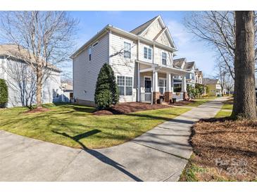 Charming two-story home boasts a welcoming front porch and a well-manicured lawn on a sunny day at 9415 Rosalyn Glen Rd, Cornelius, NC 28031