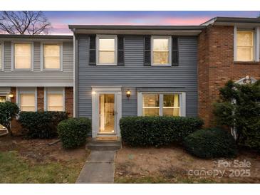 Inviting brick and gray siding townhouse with well-manicured landscaping at 1115 Scaleybark Rd # D, Charlotte, NC 28209