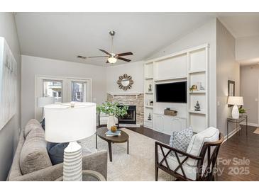 Bright living room featuring a stone fireplace, built-in shelving, and contemporary decor at 11735 Ridgeway Park Dr, Charlotte, NC 28277