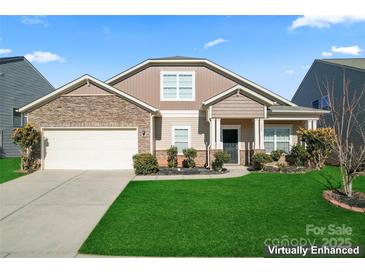 Charming two-story home featuring stone accents, a manicured lawn, and a two-car garage at 1527 Sunflower Field Pl, Matthews, NC 28104