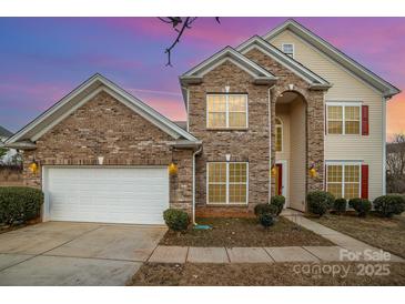 Two-story brick home with a white garage door and landscaping at 16737 Winston Oaks Ct # 297, Charlotte, NC 28213