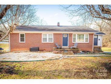 Brick ranch house with a covered porch and landscaped yard at 1750 Melrose Dr, Shelby, NC 28152