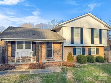 Brick ranch home with rocking chairs on the porch at 206 King Henry Ln, Gastonia, NC 28056