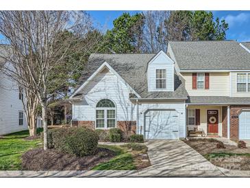 Charming townhome featuring a garage, landscaped front yard, and classic architectural details at 8636 Robinson Forest Dr, Charlotte, NC 28277