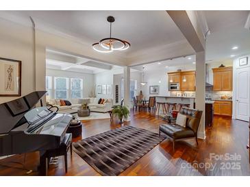 Spacious living room with hardwood floors, a fireplace, and built-in shelving at 10715 Campbell Commons Way, Charlotte, NC 28277