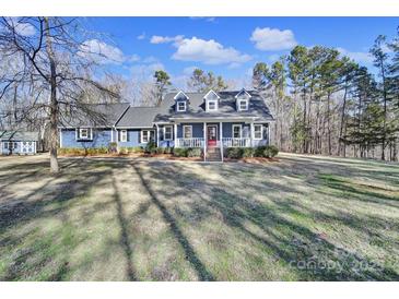 Ranch home with blue siding, white trim, and a red door at 3416 Red Fox Trl, Matthews, NC 28104