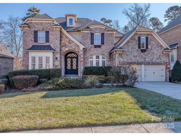 Brick front two-story house with a three-car garage and manicured lawn at 2321 Herrons Nest Nw Pl, Concord, NC 28027