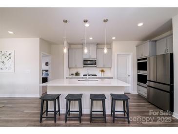 Modern kitchen with white quartz countertops and stainless steel appliances at 6420 Barcelona Way, Charlotte, NC 28214