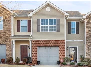 Two-story townhome with brick and stone accents, two-car garage, and landscaping at 9408 Hamel St, Charlotte, NC 28215