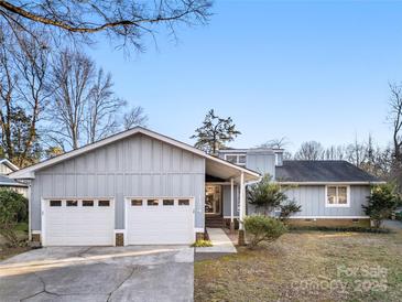 Ranch style home with a two-car garage and landscaped yard at 1124 Cameo Ct, Charlotte, NC 28270