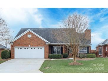 Brick ranch house with attached garage and manicured lawn at 2104 Pinefield Ct, Gastonia, NC 28056