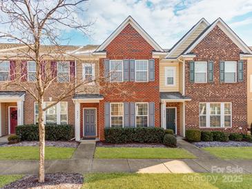 Brick front townhouse with gray door, landscaping, and walkway at 8244 Viewpoint Ln, Cornelius, NC 28031