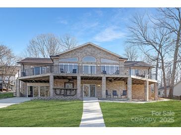 Brick home with large deck and walkway, offering lake views at 8260 Blades Trl, Denver, NC 28037