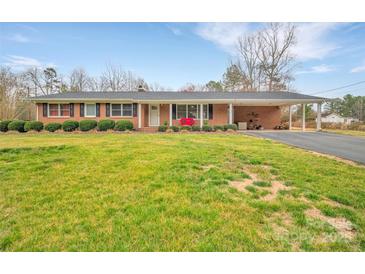 Charming brick ranch-style home with a covered front porch and well-manicured landscaping at 549 Dairy Rd, Troy, NC 27371