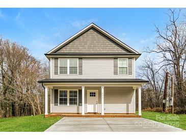 Two-story house with gray siding, a front porch, and a driveway at 571 Westside Cir, China Grove, NC 28023