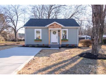 Charming gray cottage with wood accents, landscaping, and a concrete driveway at 809 S Bostian St, China Grove, NC 28023