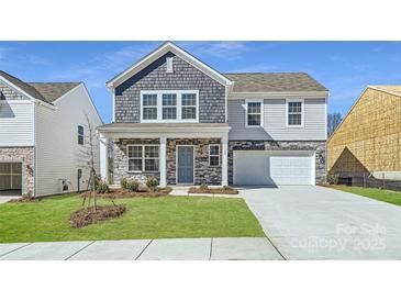 Charming two-story home boasts a mix of stone and shake siding, complemented by a well-manicured lawn at 1189 Blackburn Cir, Edgemoor, SC 29712