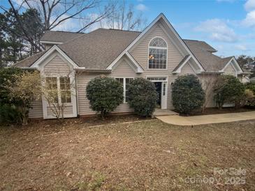 Two-story house with beige siding, a large window, and landscaping at 12064 Spinnaker Dr, Fort Mill, SC 29708