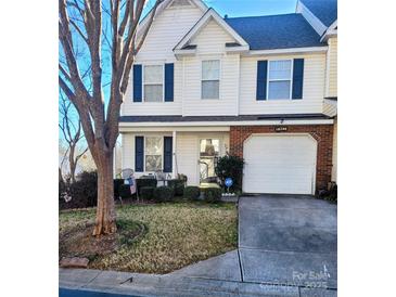 Attractive two-story townhouse with a well-maintained lawn and attached garage at 16740 Timber Crossing Rd, Charlotte, NC 28213