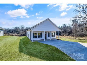 Newly constructed home with a white exterior, covered porch, and spacious driveway at 1715 Pope Ave, Gastonia, NC 28052