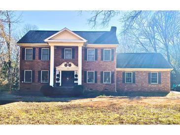 Brick two-story home with a front porch and landscaped yard at 6624 Alexander Rd, Charlotte, NC 28270