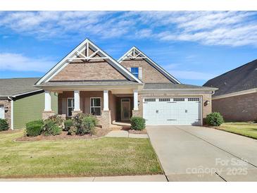 Brick front exterior of charming craftsman style home with 2-car garage at 8243 Bretton Woods Dr, Charlotte, NC 28227