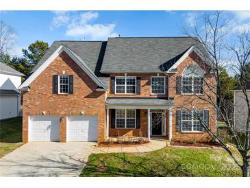 Brick house with two-car garage and landscaped yard at 8506 Delamere Ln, Charlotte, NC 28269