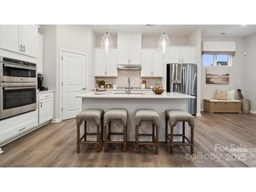 Modern kitchen with white cabinets, stainless steel appliances, and an island at 8636 Miles Gap Rd, Indian Land, SC 29707