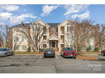 Brick condo building with ample parking and landscaping at 10240 Rose Meadow Ln # D, Charlotte, NC 28277