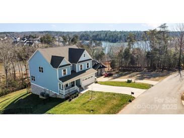 Two-story house with lake view, driveway, and landscaped lawn at 12060 Mariners Cove Ct, Lancaster, SC 29720