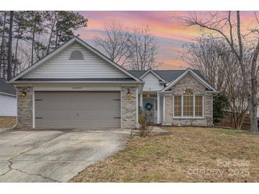 Brick ranch home with gray garage door and landscaped lawn at 14023 Kedleston Rd, Huntersville, NC 28078