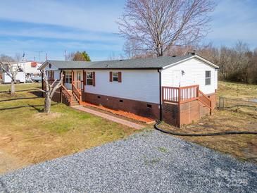 Charming single-story home with a gravel driveway, complemented by well-maintained landscaping and inviting porch at 3416 Polkville Rd, Shelby, NC 28150