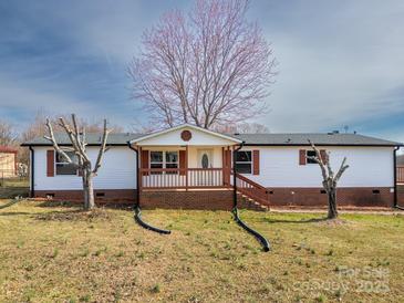 Inviting single-story home with a cozy front porch and mature trees at 3416 Polkville Rd, Shelby, NC 28150