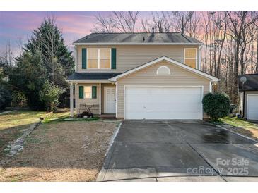 Two-story house with tan siding, green shutters, and a white garage door at 509 Tallwood Ct, Charlotte, NC 28216