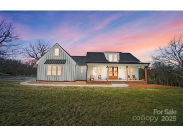 White farmhouse exterior with a wraparound porch and landscaping at 535 Grampian Rd, Mt Ulla, NC 28125