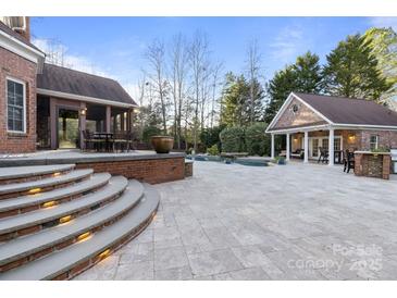 Brick patio with pool, spa, and outdoor kitchen at 6049 Bluebird Hill Ln, Weddington, NC 28104