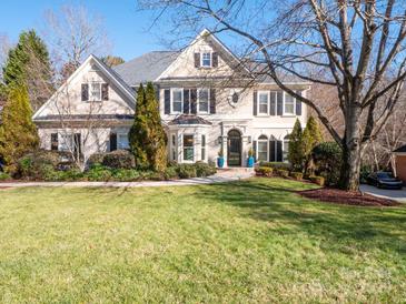 Two-story house with beige exterior, black shutters, and landscaping at 7704 Seton House Ln, Charlotte, NC 28277