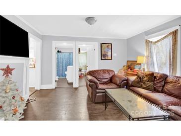 Living room with brown leather couch and view of bathroom at 911 Elm St, Kannapolis, NC 28081