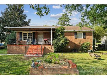 Charming brick home with a covered front porch and a small garden, creating a welcoming curb appeal at 1901 Ashcraft Ave, Monroe, NC 28110