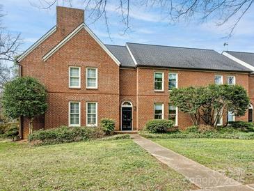 Brick townhouse with a well-maintained lawn and walkway at 2031 Queens W Rd, Charlotte, NC 28207