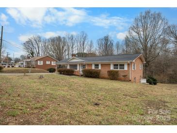 Classic red brick ranch home with a dark roof and a well maintained lawn in a suburban setting at 925 37Th Sw St, Hickory, NC 28602