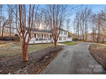 White two-story house with a spacious front porch and long driveway at 4501 Brookwood Rd, Charlotte, NC 28215