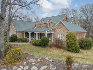 Stone house with a large front porch and landscaped yard at 5218 Shadow Pond Ln, Charlotte, NC 28226