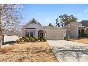 One-story home with gray siding, two-car garage, and landscaping at 9307 Dufaux Dr, Charlotte, NC 28278