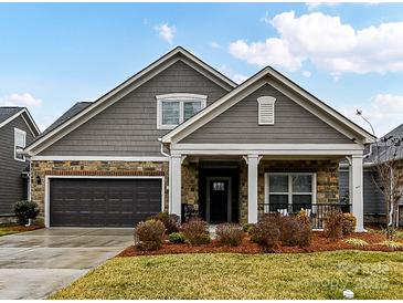 Gray-toned house with stone accents, two-car garage, and manicured lawn at 1115 Millview Ln, Matthews, NC 28104